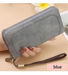 Detail of blue RFID wallet featuring vintage cut-outs and metallic zipper with wristlet