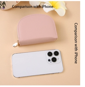 Size comparison of the pink shell card holder next to an iPhone with tropical decor
