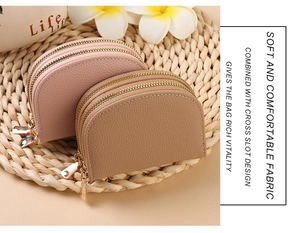 Detail of pink and khaki pebbled leather accordion wallets with three gold zippers