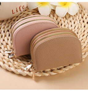 Detail of lychee pattern leather card holders in pink and khaki with dual zippers