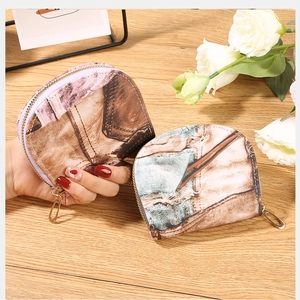 Detail of vintage denim style zipper card holder wallet on a rustic wooden table