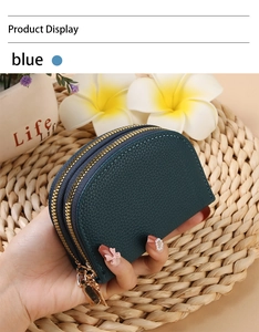 Close-up of a blue semi-circular leather accordion card holder with dual gold zippers