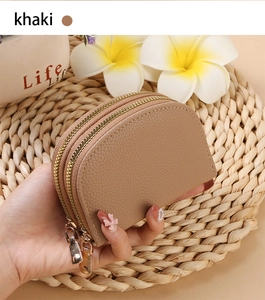 Close-up of khaki shell-shaped accordion card case with dual zippers and litchi texture
