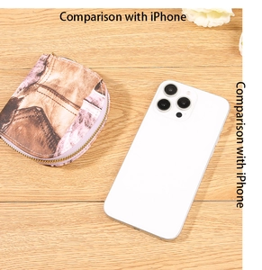 Compact denim pattern accordion card holder compared with an iPhone for size reference