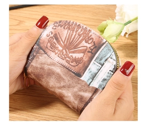 Close-up of a vintage floral accordion card holder with gold zipper and stitching detail