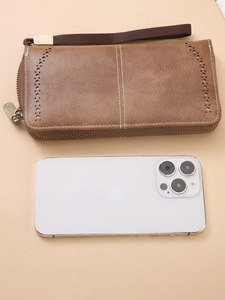 Brown RFID long leather wallet with hollow design and wrist strap compared with a phone