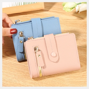 Detail of short leather folding wallet with lychee pattern and metal zipper closure