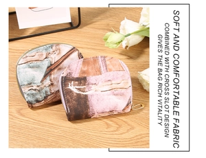 Detail of semi-circular denim patchwork coin purses with golden zippers on a wooden table