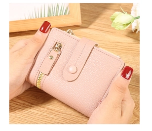 Close-up of pink lychee grain faux leather wallet with gold zipper and snap closure