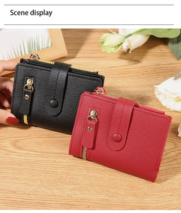 Close-up of black and red lychee grain leather wallets with snap closure and gold zippers
