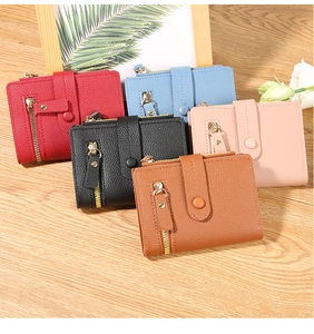 Short women's wallets in various colors on a wooden table with floral accents