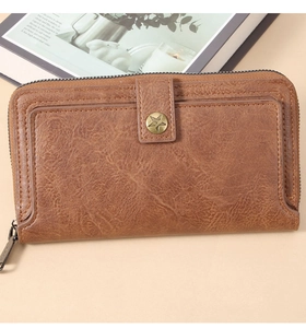 Macro view of vintage brown leather long wallet with star buckle and zipper detail