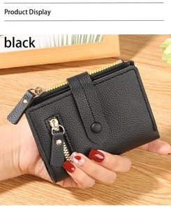 Detail of black pebbled leather wallet showing golden zipper and multi-layer slots