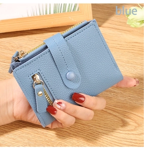 Detail of light blue lychee pattern leather wallet with double gold zippers and snap closure