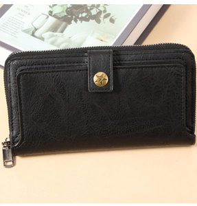 Detail of vintage long leather wallet with star buckle and zip closure in black