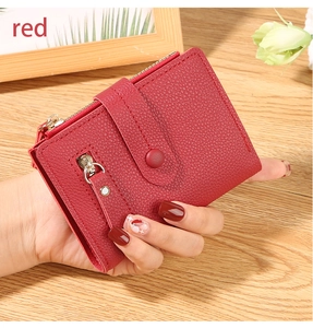 Close-up of red lychee pattern wallet with golden zippers and snap button closure