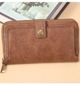 Detail of vintage long brown leather wallet with star buckle and wrap-around zipper