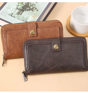 Detail of vintage long wallets in brown and coffee with star embossed button and zip