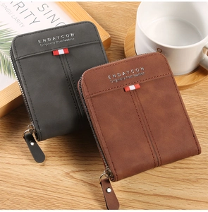 Detail view of retro bifold zippers wallets in dark grey and brown on a wooden desk