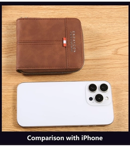 Brown leather zip wallet showing compact size compared to a phone on a wood desk