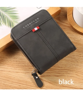 Detailed macro view of vintage black zipper wallet with silver embossed text and fabric tag