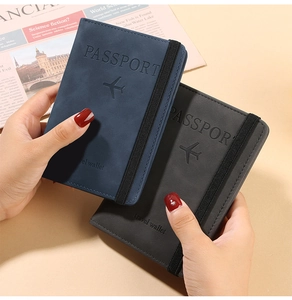 Close-up of PU leather passport covers with elastic bands and embossed travel logos