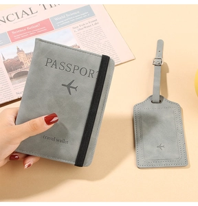 Close-up of gray textured PU leather passport holder and luggage tag with travel strap