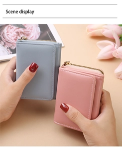 Detail von minimalistischen Damen-Geldbeuteln in Grau und Rosa mit goldfarbenen Reißverschlüssen