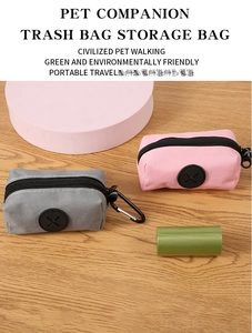 Detail view of portable pet waste bag dispensers in grey and pink with metal carabiner