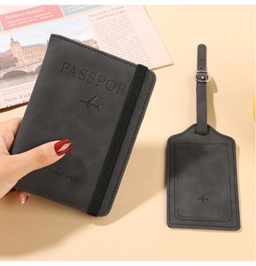 Detail of dark grey travel passport holder and matching luggage tag on neutral background