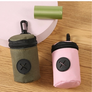 Detail of olive green and pink pet waste bag dispensers with plastic carabiner clips