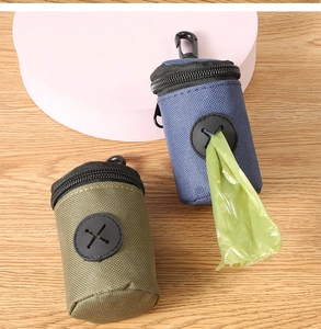 Detail view of portable pet waste bag dispensers in blue and green with a carabiner clip