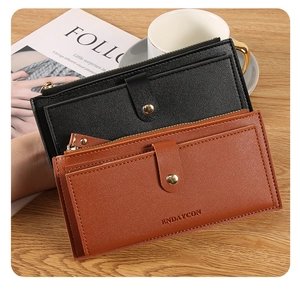 Slim leather wallets in black and brown with card slots and gold zippers on a desk