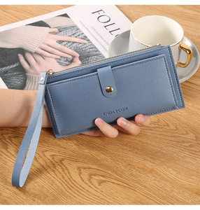 Close-up of blue textured leather wallet with gold hardware and secure snap pocket detail