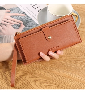 Close-up of brown textured leather long wallet with wrist strap and zipper compartment