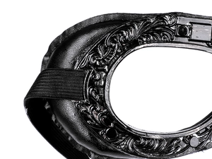 Close-up of steampunk aviator goggles featuring ornate floral carvings and black leather padding