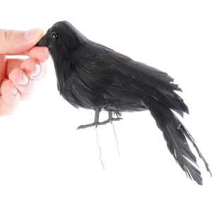 Close-up of artificial black crow with feathers and wire legs for Halloween decor