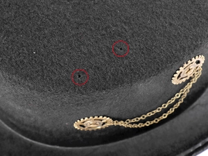 Macro detail of steampunk top hat showing vintage brass gears and metal chain accents