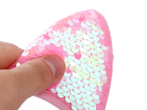 Détail de paillettes roses irisées sur un serre-tête oreilles de chat festif