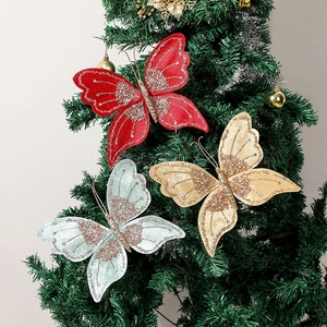 Close-up of glittery butterfly ornaments in red, gold and blue on a Christmas tree branch