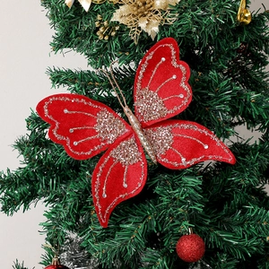 Detail of red velvet Christmas butterfly with champagne glitter and pearls on tree branches