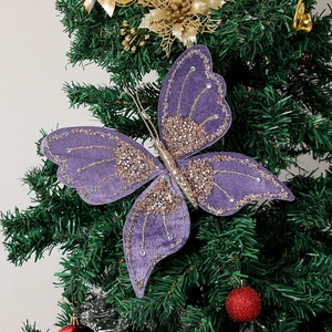 Close-up of purple velvet Christmas butterfly with gold glitter and rhinestones on a tree
