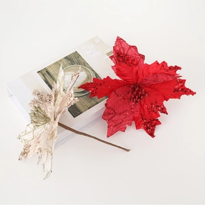 Detail of glittered fabric poinsettia flowers in red and champagne for Christmas decor