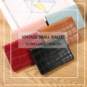 Detail view of colorful crocodile pattern small wallets on a wooden surface with vintage design