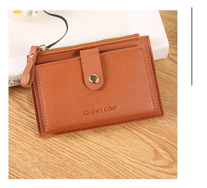 Brown leather card holder wallet on a wooden table with zipper and snap pocket