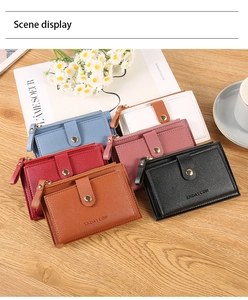 Short zipper wallets for women in six colors arranged on a wooden table with daisies