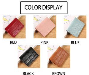 Detail display of small faux crocodile wallets in red, pink, blue, black, and brown