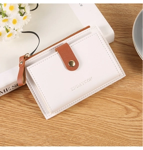 Detail of minimalist cream leather wallet with brown litchi pattern and gold zipper
