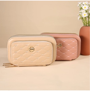 Détail des trois compartiments à fermeture éclair et matelassage en cœur sur le petit sac