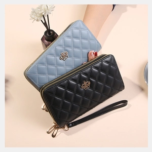 Détail de portefeuilles en cuir PU matelassé bleu et noir avec couronnes dorées et zips